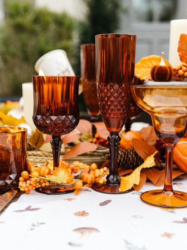 Flûte ambrée effet cristal posée sur une table romantique avec bougeoir et décoration automnale
