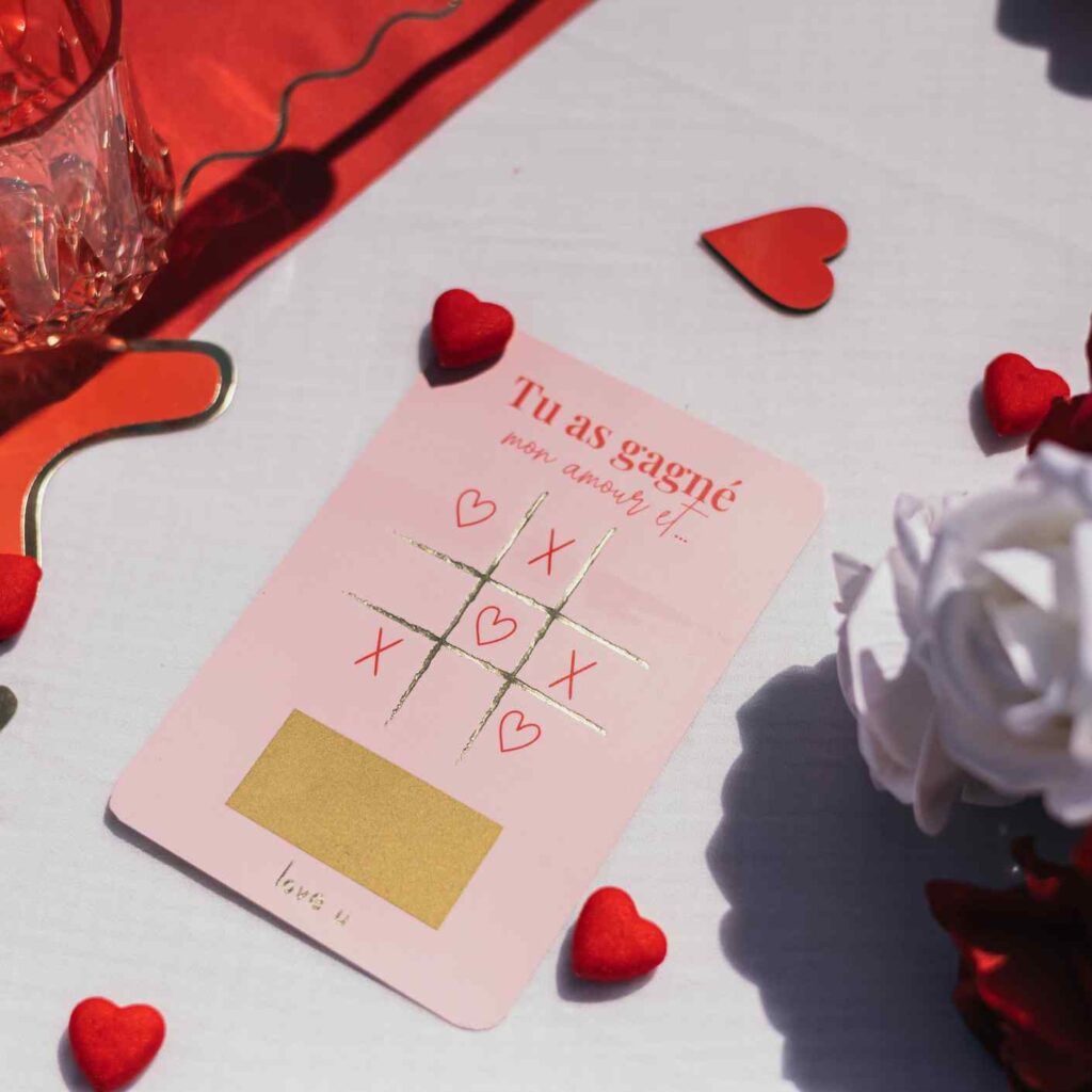 Jeu à gratter amour présenté sur une table romantique