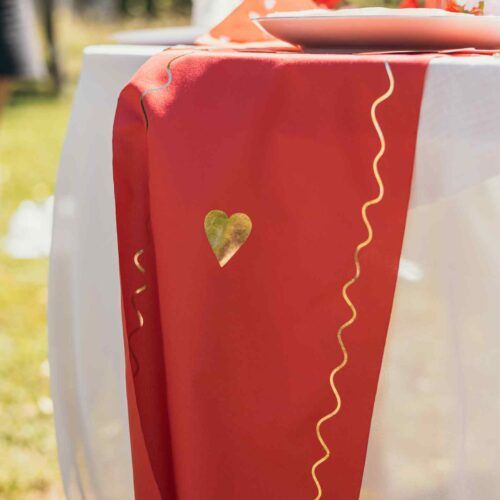 Détail du chemin de table Dame de Cœur en tissu rouge et or