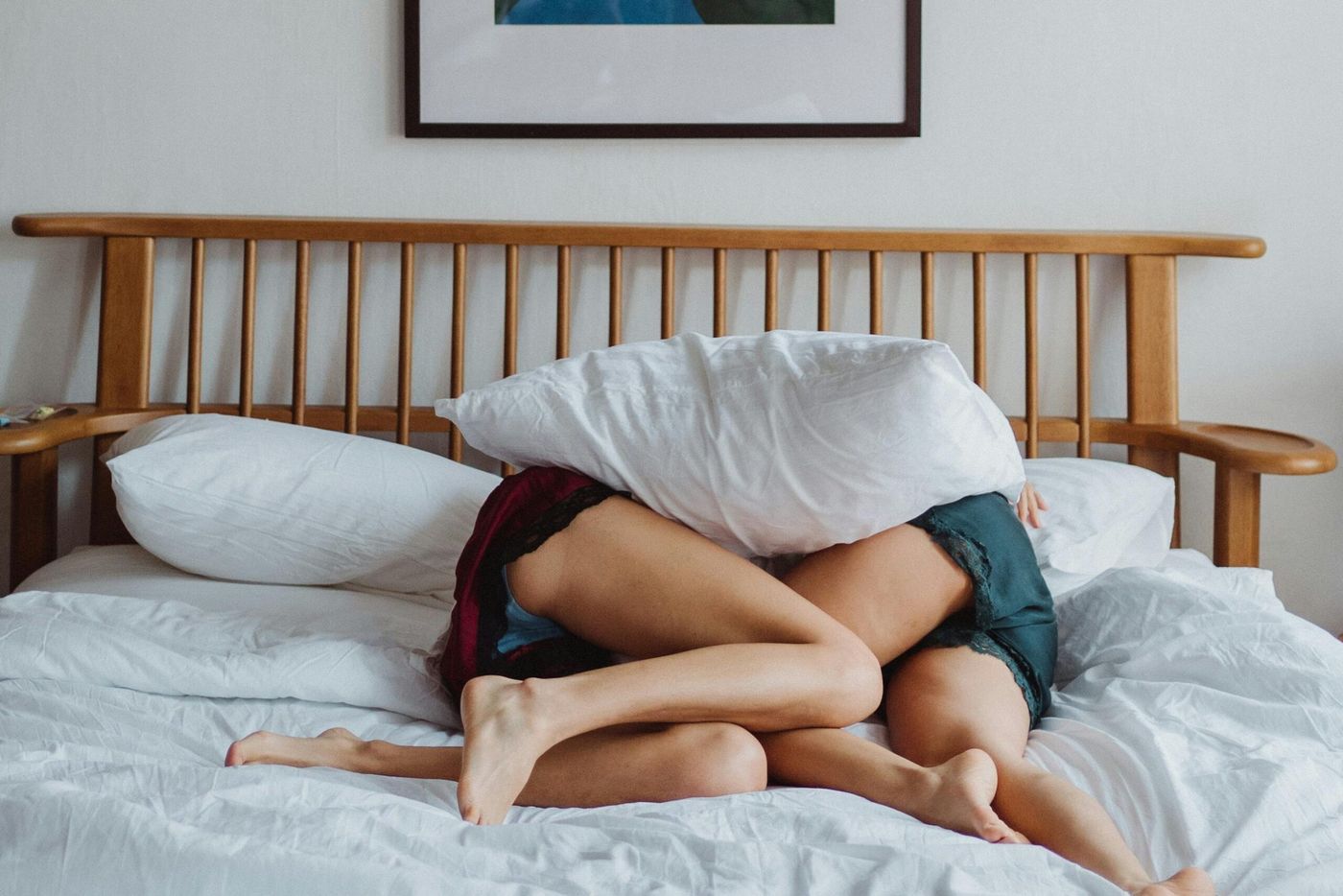 Couple complice et tendre enlacé dans un lit, lumière douce du matin